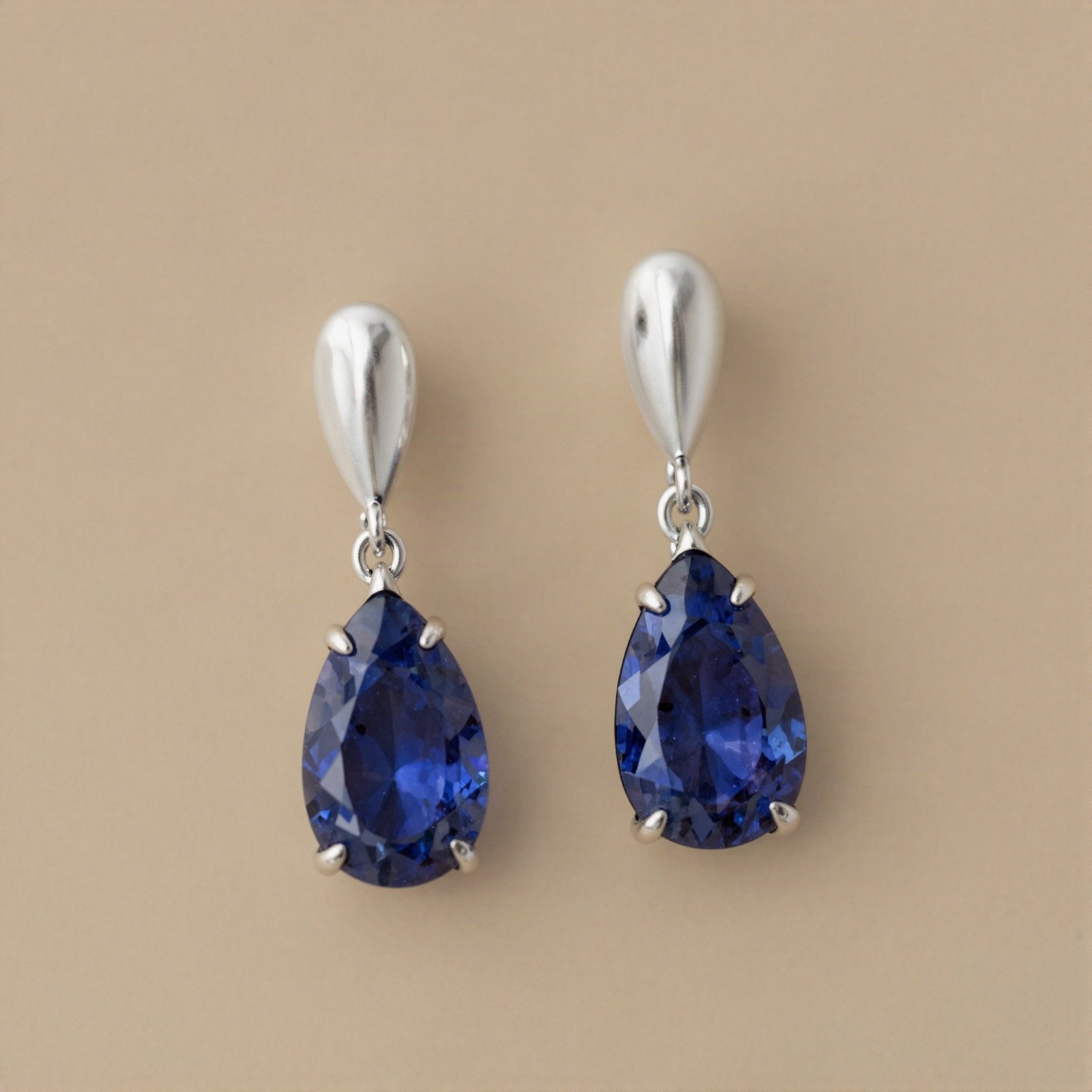 A pair of white gold drop earrings with blue sapphire teardrops