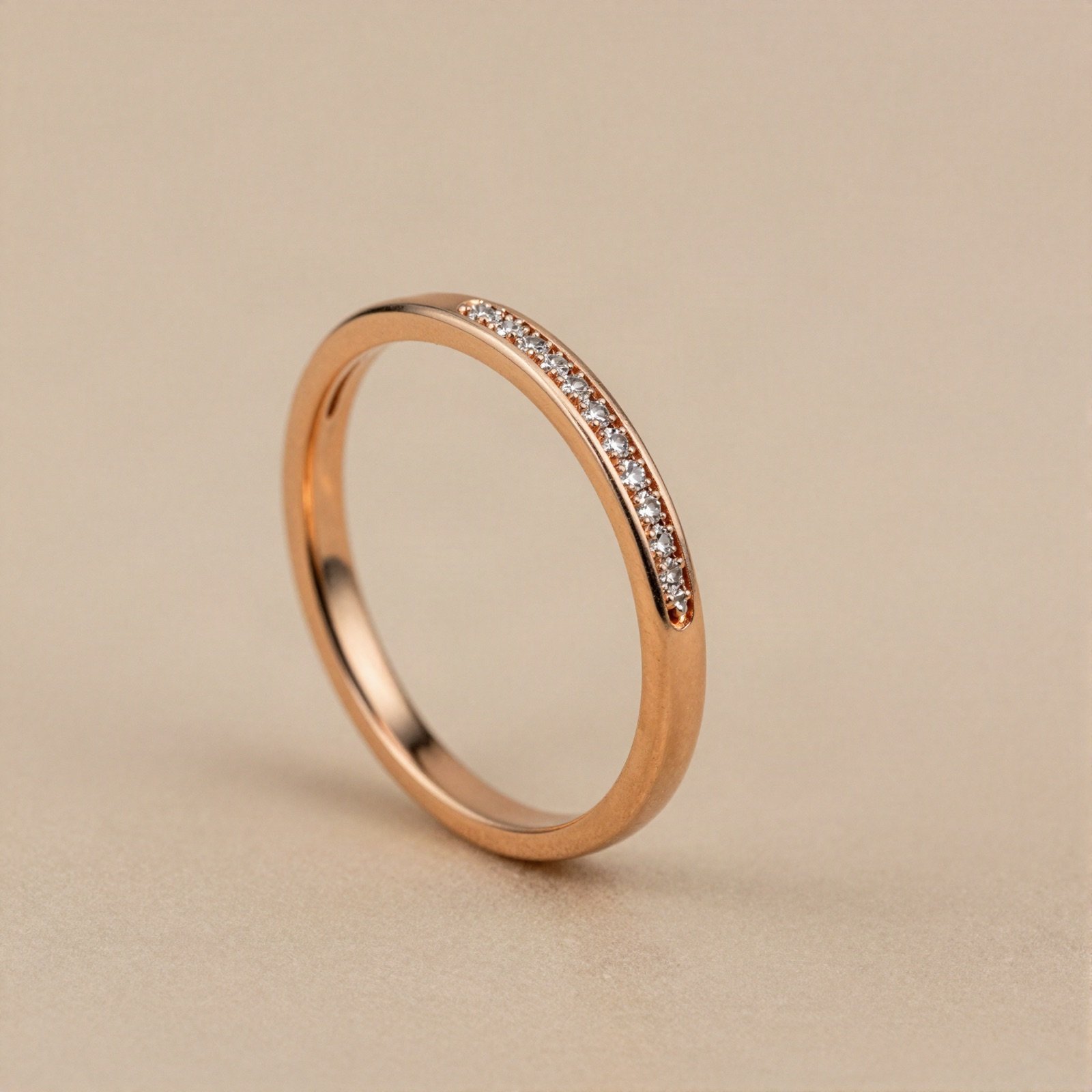 A thin rose gold stacking ring set with a row of small diamonds