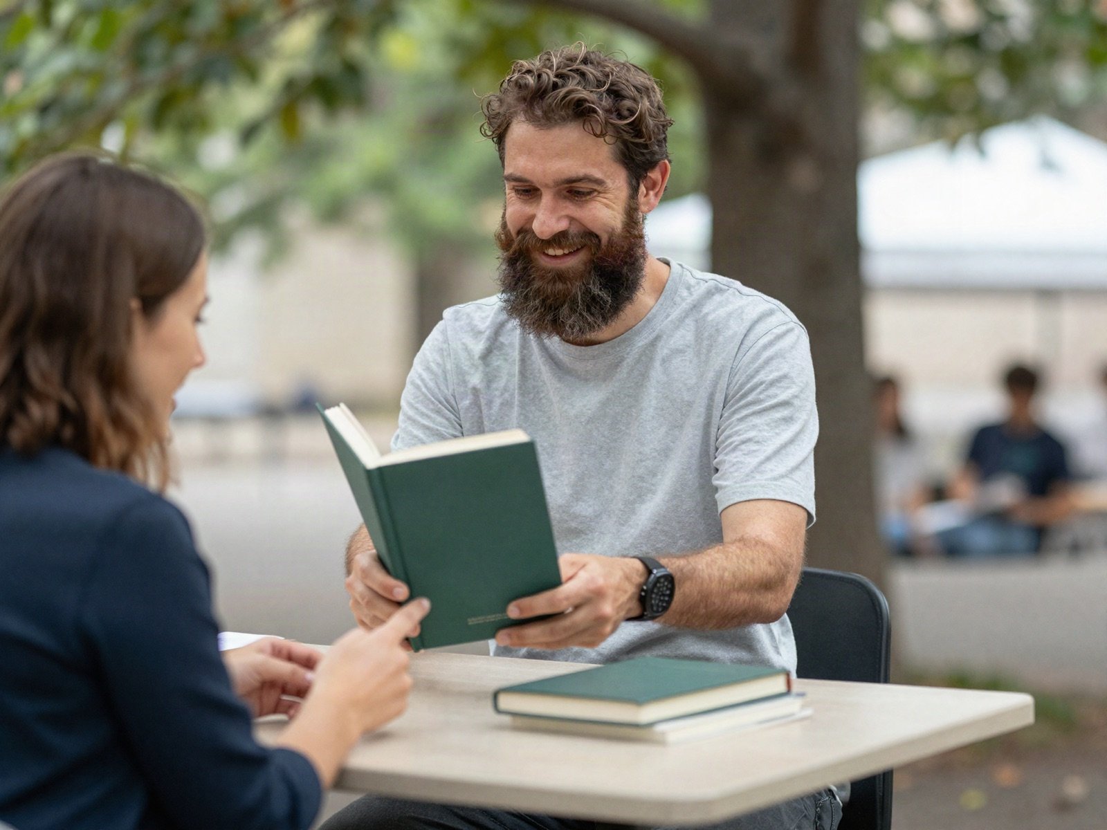 مؤلف يسلّم كتابًا موقّعًا لقارئ في معرض كتب في الهواء الطلق